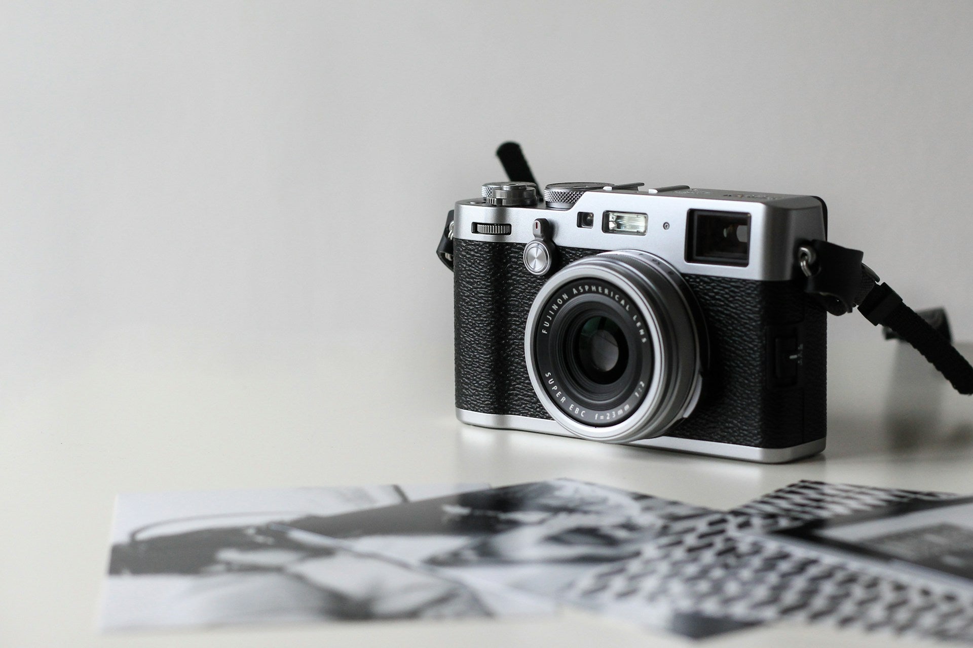 Black and gray film camera near printed photos.