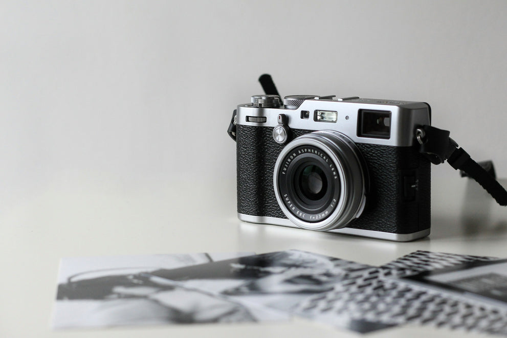 Camera on white background with print photos to make a slideshow. 